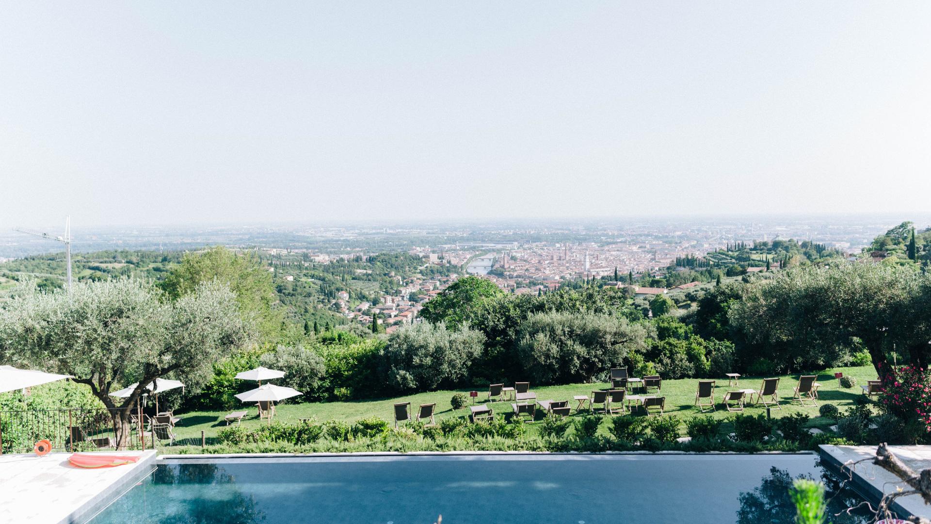 Vista panoramica della città con piscina e giardino in primo piano.