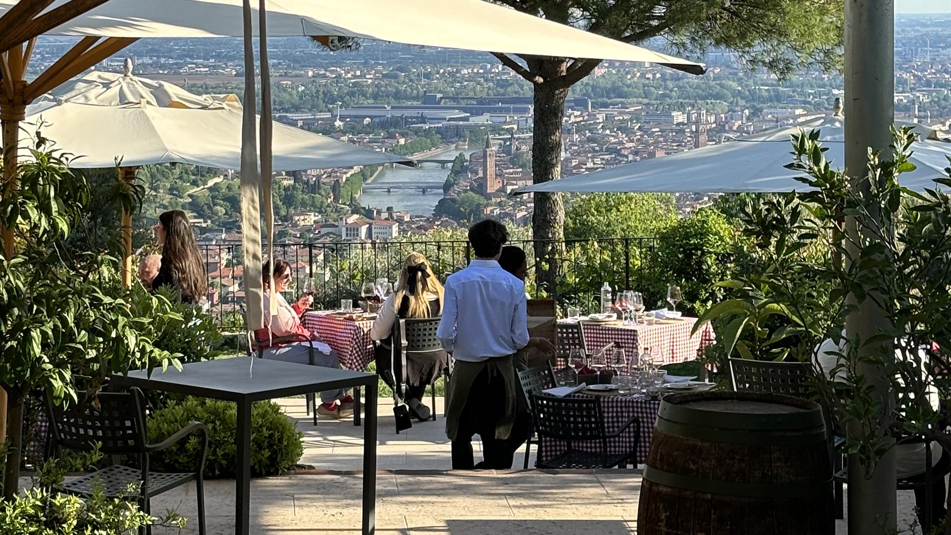 Ristorante all'aperto con vista panoramica sulla città e il fiume.