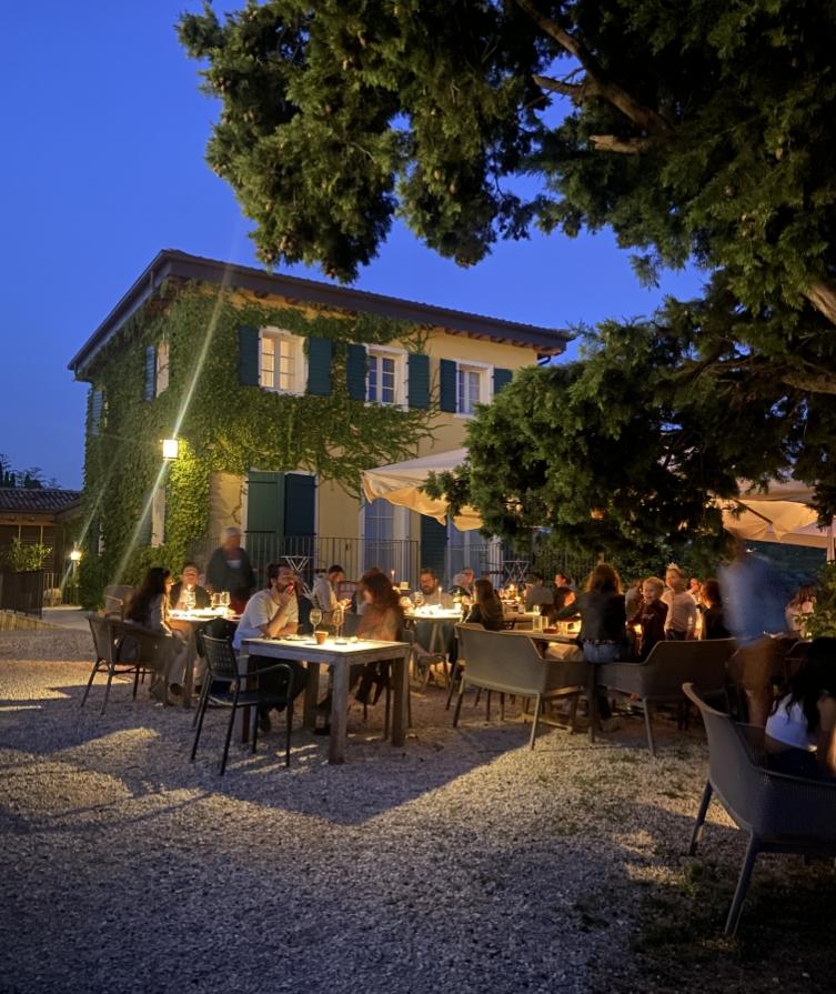 Cena all'aperto in un ristorante con luci soffuse e atmosfera accogliente.